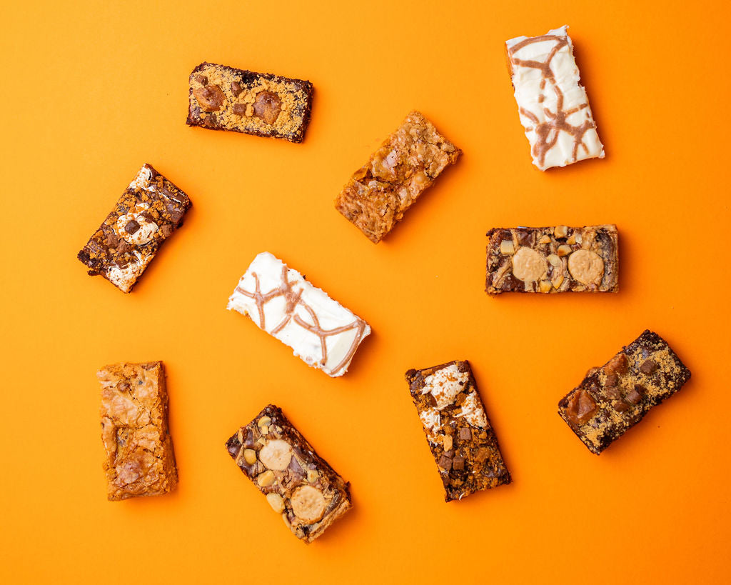 Nine brownies arranged on a bright orange background.