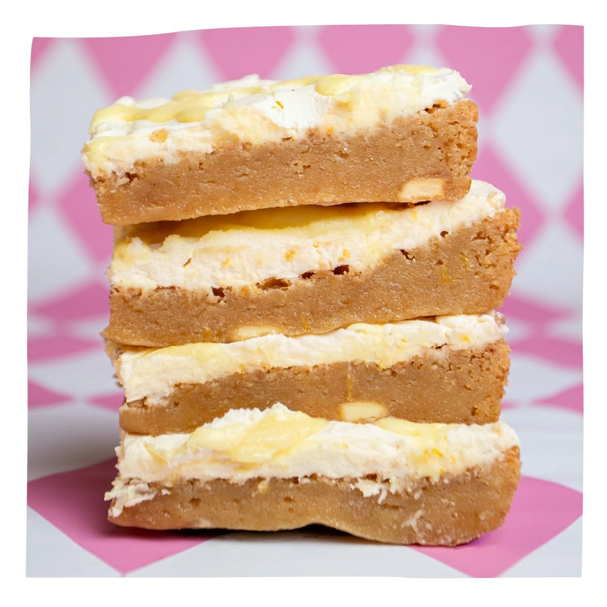 Four stacked brownies, set against a pink and white patterned background.